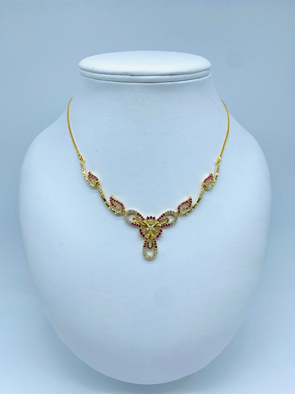Genuine yellow gold necklace with sides ornamented with ruby leaves and a delicate flower in the middle.