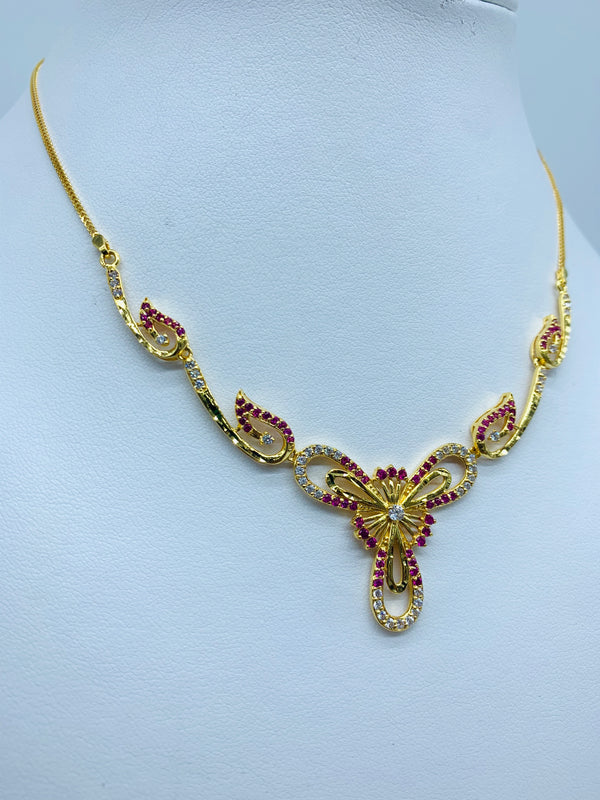 Gleaming gold necklace with modern petal like shape designs and floral designs in the centre studded with rubies and CZ stones. 